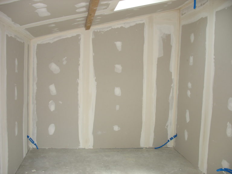 Photographie des murs vierges d'une pièce en rénovation