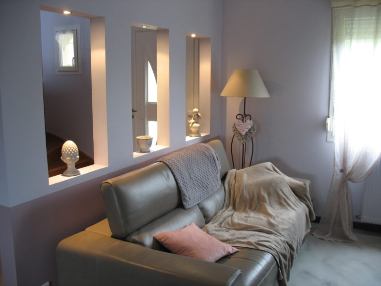 Photographie d'un canapé gris dans une pièce rénovée blanche et rose