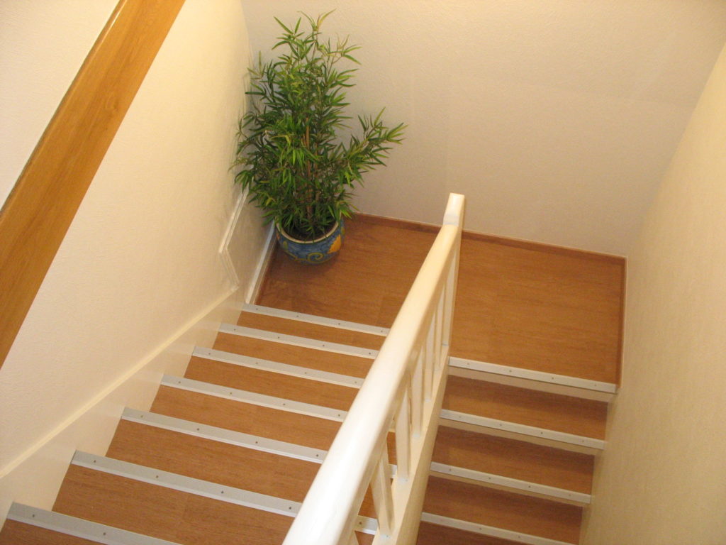 Photo d'un escalier pris d'en haut. Le sol et les murs ont été rénovés
